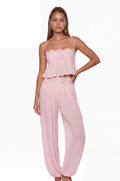 Completo con top corto rosa bordato di pizzo e pantaloni harem plissettati