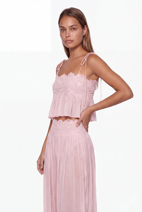 Completo con top corto rosa bordato di pizzo e pantaloni harem plissettati